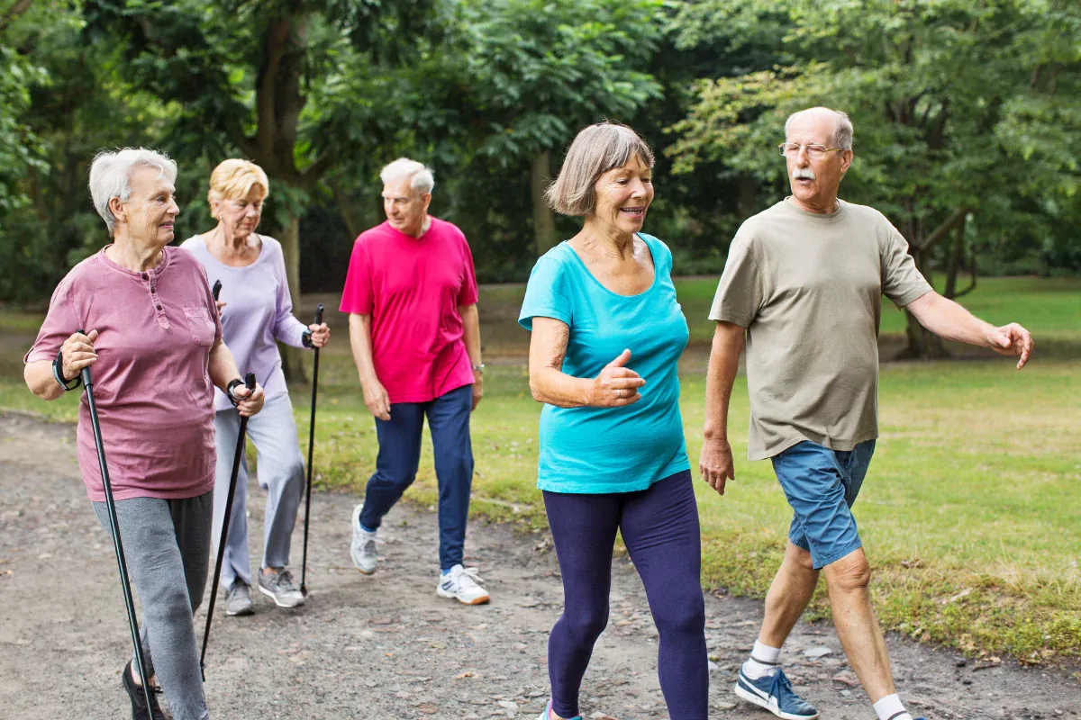 Un grupo de personas mayores caminando en un parque en un día soleado