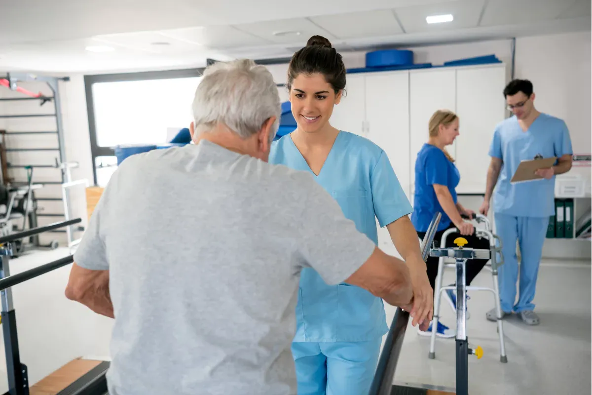 Paciente anciano sometido a fisioterapia con andador