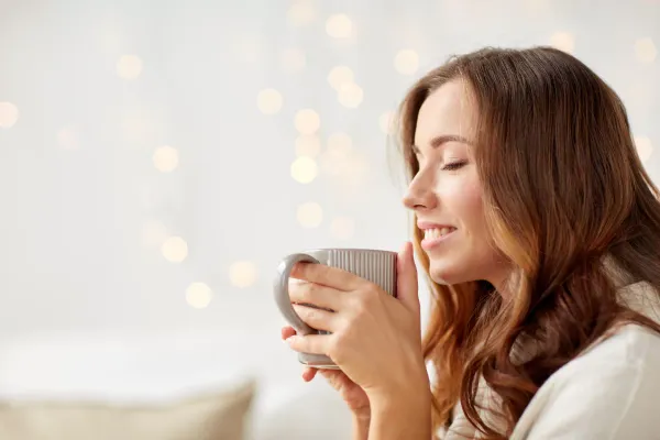 Mujer tomando café con expresión de felicidad y bienestar